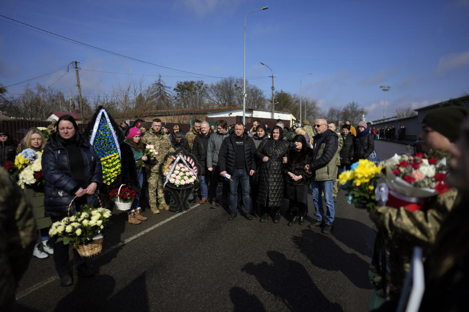 Relatives attend the funeral of 29 year old Yana Rikhlitska, a Ukrainian army medic killed in the Bakhmut area, in Vinnytsia, Ukraine, Tuesday, March 7, 2023. Just over a week ago, Yana Rikhlitska was filmed by The Associated Press as she helped treat wounded soldiers in a field hospital of Bakhmut area which has been pulverized as Russia presses a three-sided assault to seize it. (AP Photo/Thibault Camus)