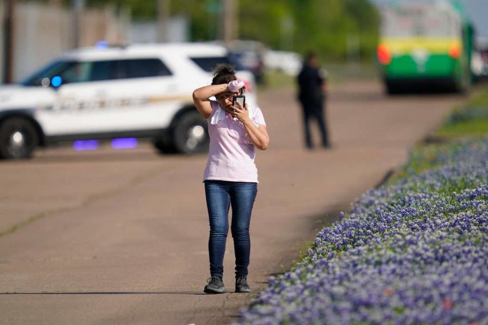 An employee from a local business talks on her phone after police released her from the scene of a mass shooting at an industrial park in Bryan, Texas on April 8, 2021.