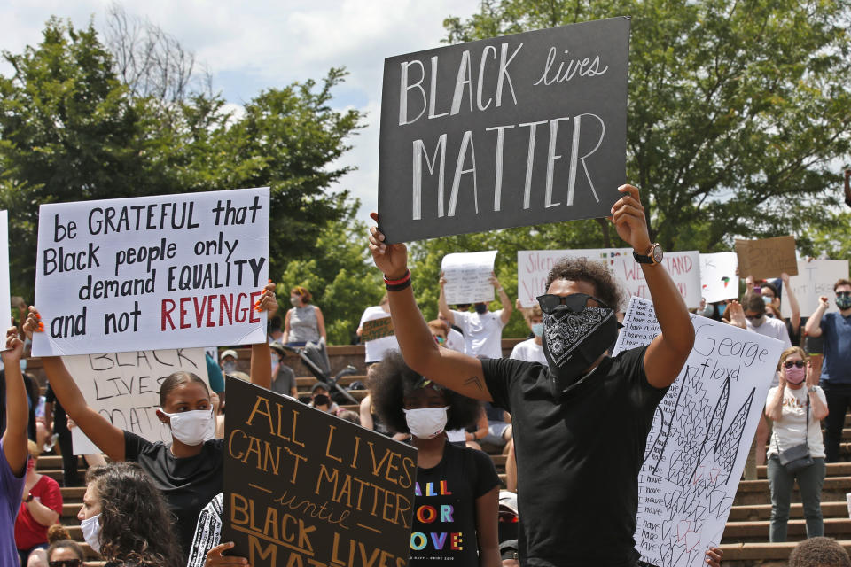 Atlanta Hawks guard Trae Young, right, holds a "Black Lives Matter" sign at a peaceful rally Monday, June 1, 2020, in his hometown of Norman, Okla., calling attention to the killing of George Floyd by Minneapolis police on May 25. (AP Photo/Sue Ogrocki)