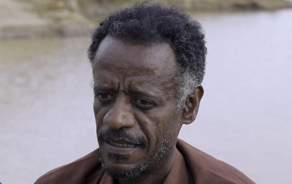 Dr. Tewodros Tefera, an Ethiopian refugee doctor who has been documenting the arrival of the bodies and their injuries, is interviewed beside the Setit river at Wad el Hilu, Sudan on Wednesday, Aug. 4, 2021. Dozens of bodies have been found floating down the Setit River, known in Ethiopia as Tekeze River, in southwestern Sudan in the past week. (AP Photo/Mohaned Awad)