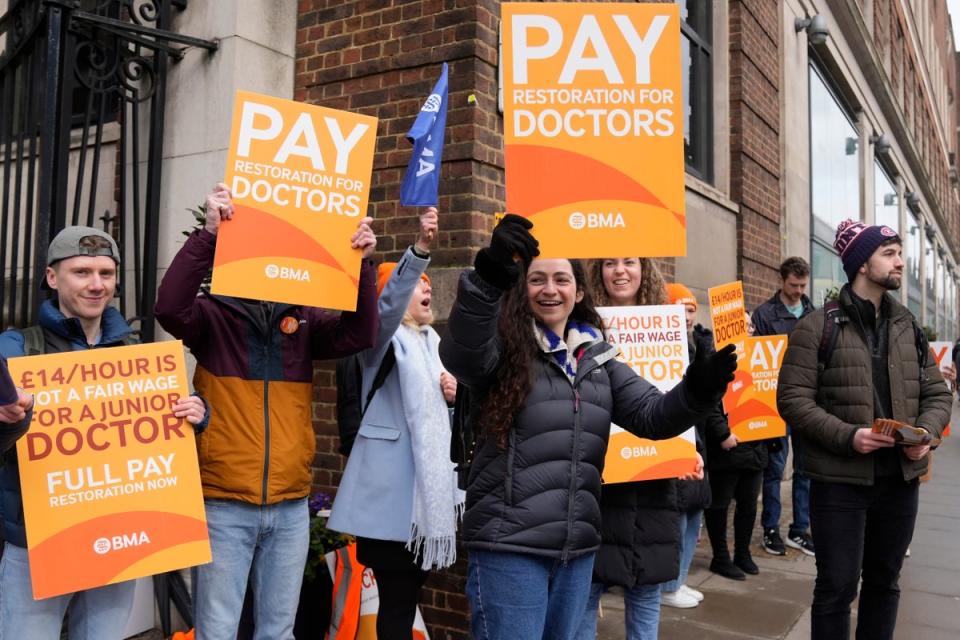 Junior doctors hold placards on a picket line outside St Mary's Hospital in London on Tuesday (AP)