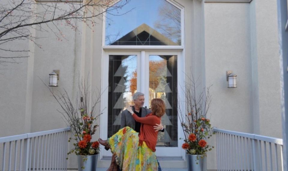 Just like a couple entering their first home, Mike carries Janine over the threshold of every new show home they live in.