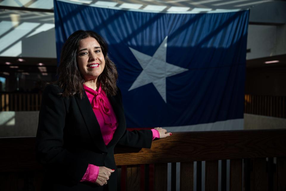 Diane Gonzalez stands in front of the Texas state flag after being appointed to the Port of Corpus Christi Commission by the Nueces County Commissioners Court at the county courthouse on Jan. 4, 2023.