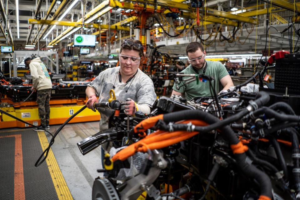 Amanda McDermott works on a chassis for a Ford F-150 Lightning pickup truck alongside TJ Bobola, right, at the Rouge Electric Vehicle Center in Dearborn on Monday, May 15, 2023. McDerrmott and her mother, Suzie Roksandich-McDermott, are the only mother/daughter team working at different sections on the assembly line in a plant that's preparing to double its run rate to 150,000 vehicles annually.