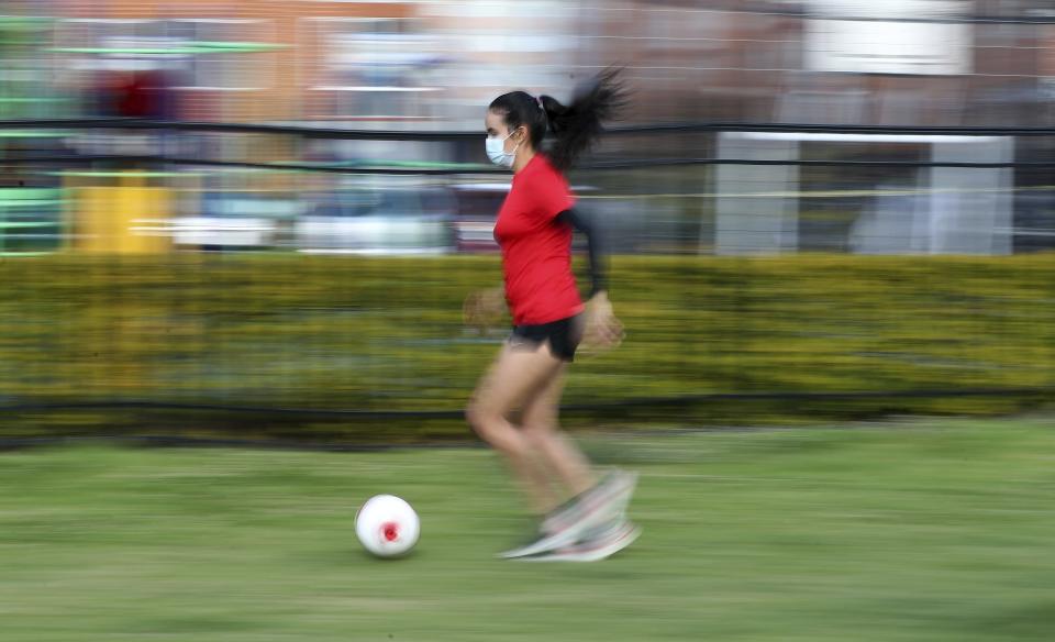 María Alejandra Peraza, futbolista venezolana que jugó la campaña anterior con Millonarios de Colombia, entrena con mascarilla y en solitario en Bogotá, el jueves 21 de mayo de 2020 (AP Foto/Fernando Vergara)