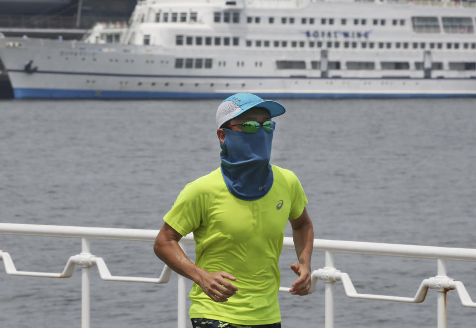 A man wearing a face mask to protect against the spread of the new coronavirus runs at along the waterfront in Yokohama near Tokyo, Monday, Aug, 10, 2020. (AP Photo/Koji Sasahara)