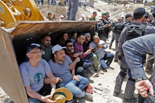 Demonstrators try to halt a digger in the Palestinian Bedouin village of Khan al-Ahmar in the occupied West Bank on July 4, 2018