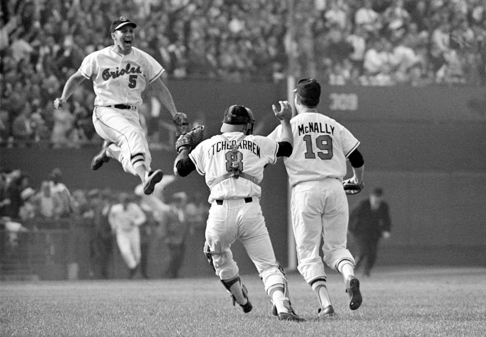 Baltimore Orioles third baseman Brooks Robinson (5) leaps across the infield to congratulate pitcher Dave McNally (19) and Orioles catcher Andy Etchebarren (8) after the final out in a World Series baseball game against the Los Angeles Dodgers in Baltimore, Md., on Oct. 9, 1966. Robinson, whose deft glovework and folksy manner made him one of the most beloved and accomplished athletes in Baltimore history, has died, according to a joint announcement by the Orioles and his family Tuesday, Sept. 26, 2023.