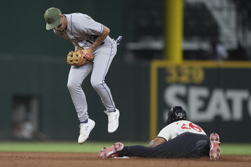 Colorado Rockies second baseman Alan Trejo, left, holds onto the ball as Texas Rangers' Ezequiel Duran, right, steals second base during the eighth inning of a baseball game in Arlington, Texas, Friday, May 19, 2023. (AP Photo/LM Otero)