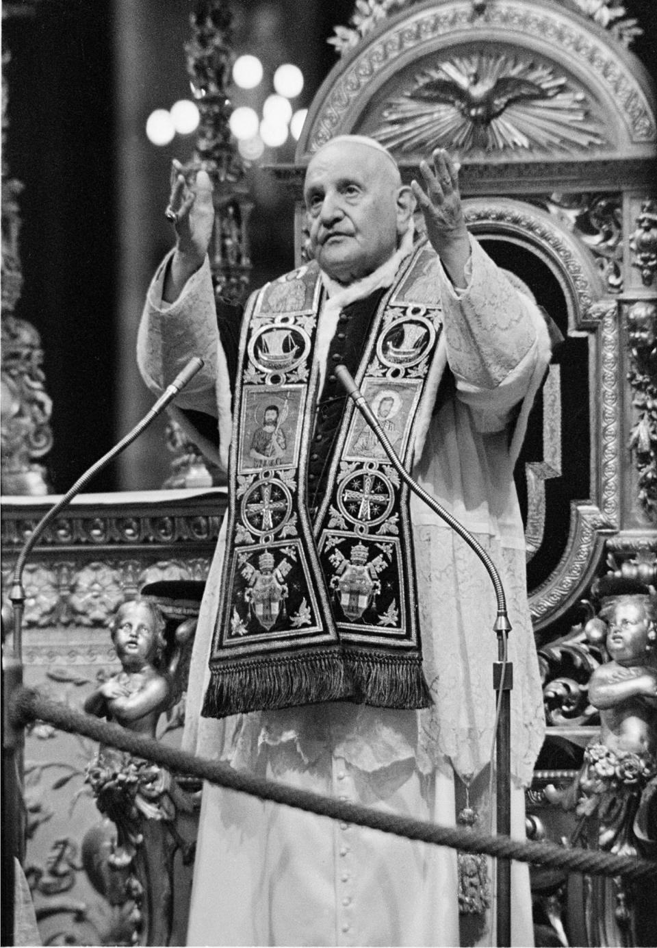 FILE - In this Dec. 8, 1962 file photo, Pope John XXIII, standing in front of his throne, imparts his blessing upon the Fathers of the Roman Catholic Ecumenical Council and all present at the closing ceremony of the council's first phase, at the Vatican. While much of the focus of Sunday's dual canonization will be on Pope John Paul II's globe-trotting, 26-year papacy and his near-record sprint to sainthood, many older Catholics will be celebrating the short but historic pontificate of the "Good Pope," John XXIII. (AP Photo/File)