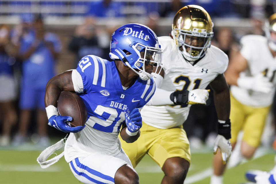 Duke's Peyton Jones (21) carries the ball ahead of Notre Dame's Nana Osafo-Mensah (31) during the first half of an NCAA college football game in Durham, N.C., Saturday, Sept. 30, 2023. (AP Photo/Ben McKeown)