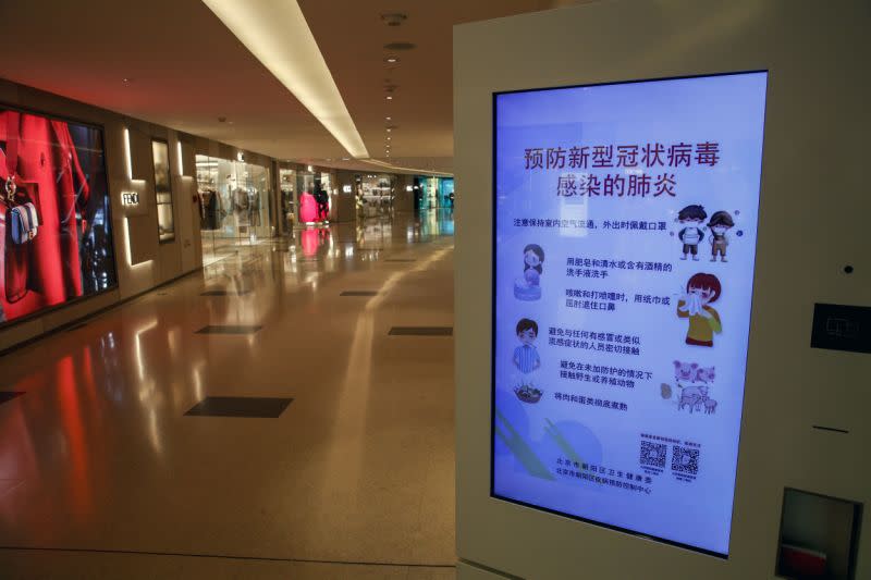 Una pantalla electrónica muestra un aviso de precaución del coronavirus en un centro comercial de lujo abandonado en Beijing. (Foto AP/Andy Wong)