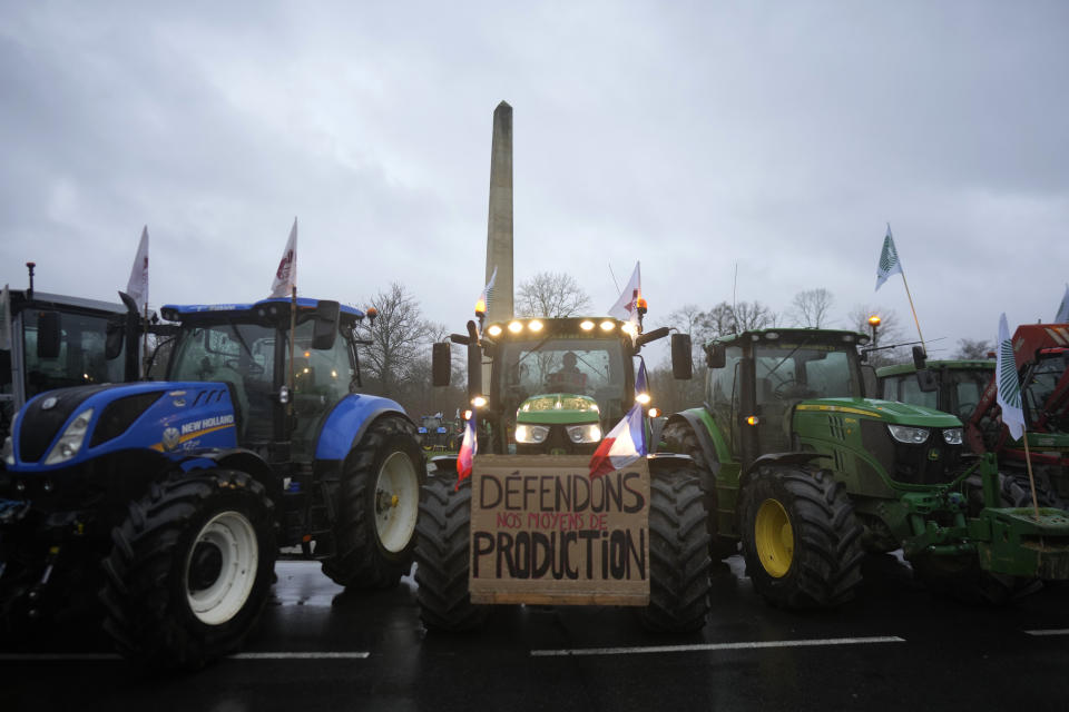 Farmers block a roundabout in Fontainebleau, south of Paris, Friday, Jan. 26, 2024 in Paris. Snowballing protests by French farmers crept closer to Paris with tractors driving in convoys and blocking roads in many regions of the country to ratchet up pressure for government measures to protect the influential agricultural sector from foreign competition, red tape, rising costs and poverty-levels of pay for the worst-off producers. (AP Photo/Thibault Camus)