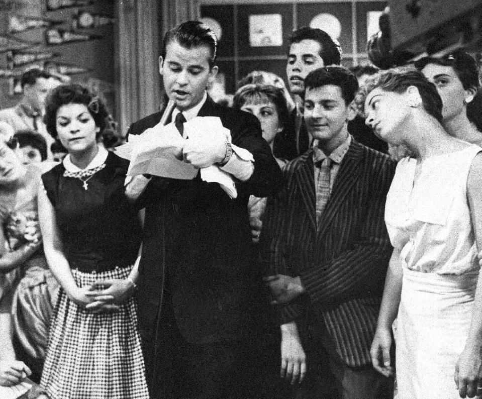 FILE - In this 1957 file photo, Dick Clark is seen surrounded by fans during a television broadcast of "American Bandstand." Clark, the television host who helped bring rock `n' roll into the mainstream, died Wednesday, April 18, 2012 of a heart attack. He was 82. (AP Photo/File)