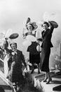 <p>A group of women stand on the roof of Rockefeller Center with balloons in hand. The iconic building was completed in 1931. </p>