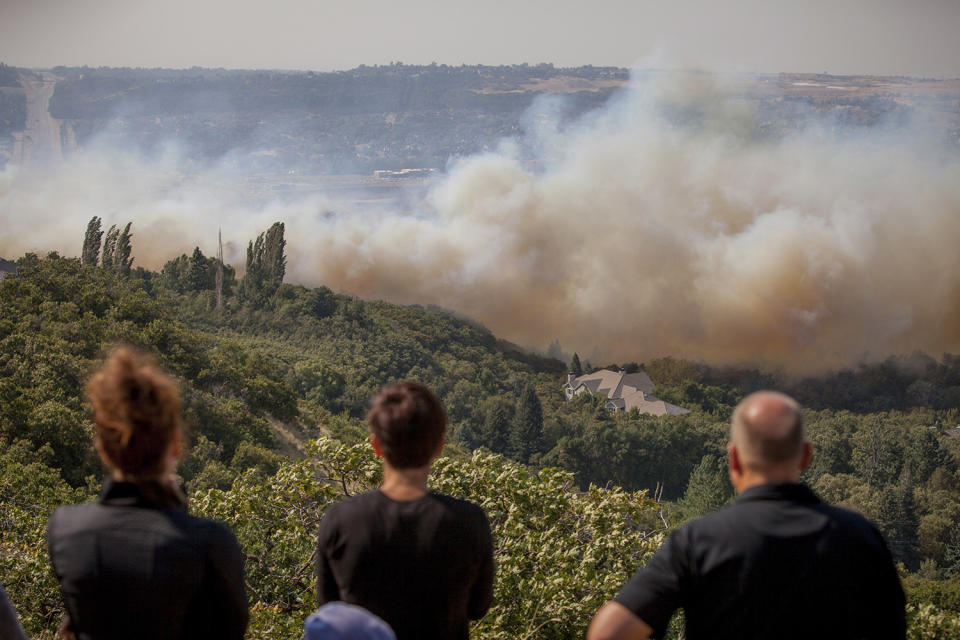 <p>Neighbors watch a wildfire burn through residential areas near the mouth of Weber Canyon near Ogden, Utah, Sept. 5, 2017. (Photo: Benjamin Zack/Standard-Examiner via AP) </p>