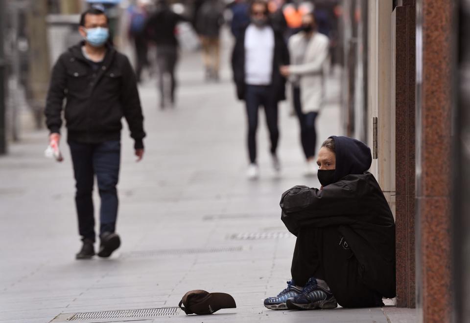 A man begs for money along a street in Melbourne's city centre on September 17, 2020.