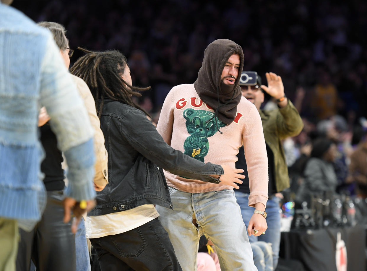 Bad Bunny disfrutó el partido entre Los Angeles Lakers y los Memphis Grizzlies, mientras mostró lo que podría suponerse que es es una nueva propuesta de moda: el pantalón roto en la zona genital. (Photo by Kevork Djansezian/Getty Images)