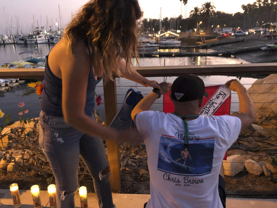 JJ Lambert, 38, and his fiancee, Jenna Marsala, 33, hang up a dive flag in remembrance of the victims of the Conception boat fire at a memorial site on Monday, Sept. 2, 2019, in Santa Barbara, Calif. (Photo: Stefanie Dazio/AP)