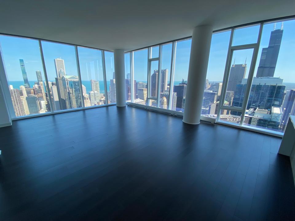 The living room in the penthouse at wolf point east with windows overlooking skyline