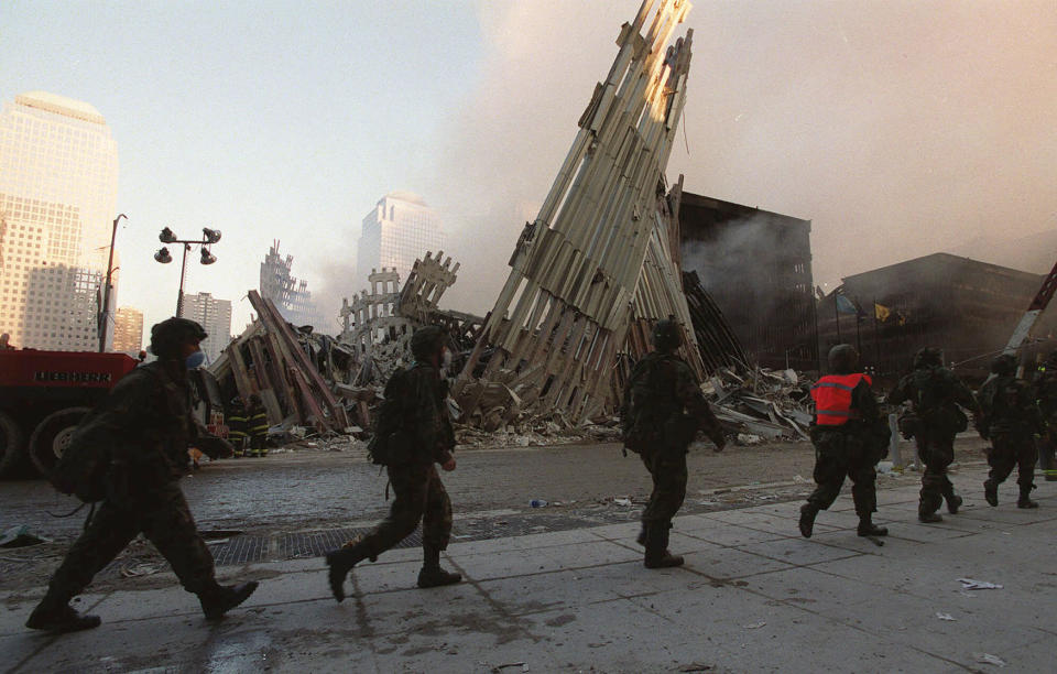 <p>National Guardsmen march past the wreckage of the World Trade Center towers in New York, Sept. 13, 2001. (Photo: Stephen Chernin/AP) </p>