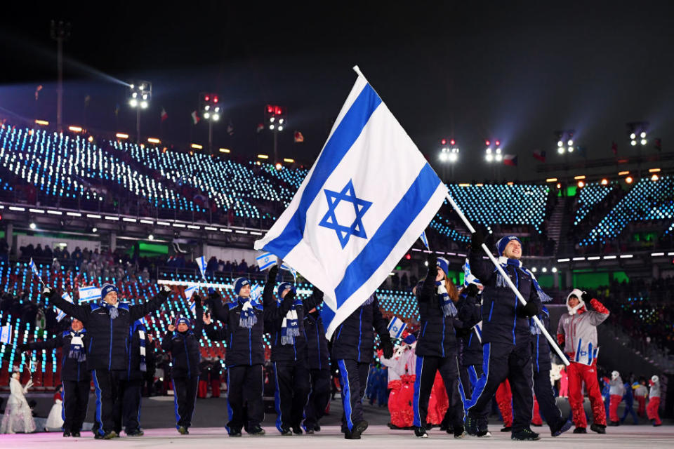 <p>Flag bearer Alexei Bychenko of Israel and teammates enter the stadium wearing navy winter apparel featuring cobalt blue stripes along their pants and jacket zippers during the opening ceremony of the 2018 PyeongChang Games. (Photo: Matthias Hangst/Getty Images) </p>