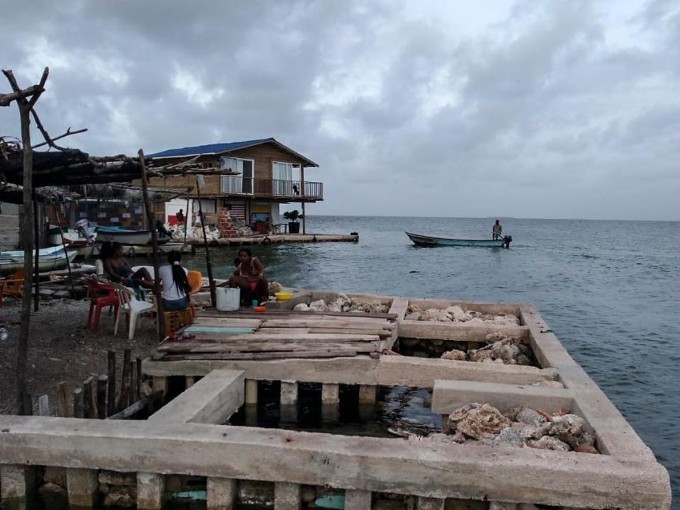 Locals sit near the shore of Santa Cruz del Islote island, located in the Colombian Caribbean