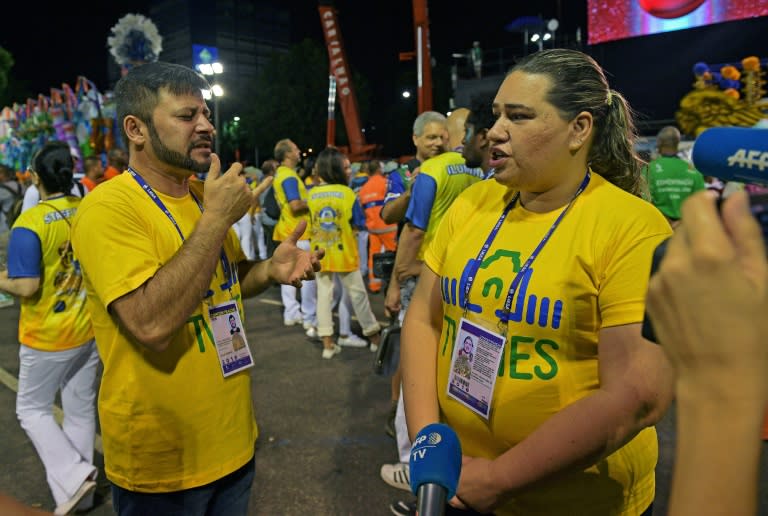 Aulio Nobrega (L) and Daniela Abreu use sign language to communicate during the second night of Rio's Carnival at the Sambadrome in Rio de Janeiro