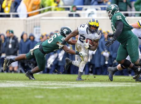 Oct 20, 2018; East Lansing, MI, USA; Michigan Wolverines running back Karan Higdon (22) runs though the tackle of Michigan State Spartans linebacker Brandon Bouyer-Randle (26) during the second half of a game at Spartan Stadium. Mandatory Credit: Mike Carter-USA TODAY Sports