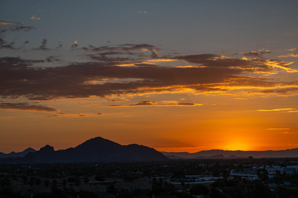 The sun rises over Camelback Mountain during a heat wave in Phoenix. A massive heat wave will build in the southern U.S. and expand into the Pacific Northwest this week. / Credit: Ash Ponders via Getty Images