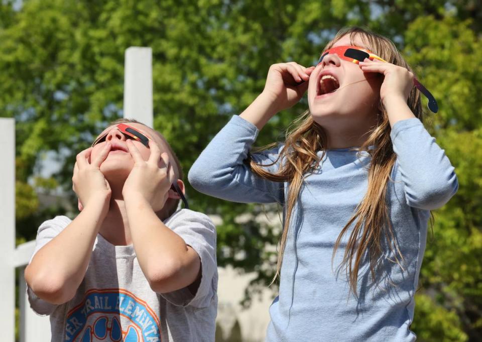 10-year-old Maddox Montgomery, left, and 8-year-old Leighton Montgomery look at the eclipse through special glasses Monday at the Old Town Amphitheater in downtown Rock Hill.