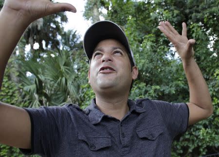 Alain Izquierdo, a Havana butcher and one of 15 survivors of the 32 Cuban migrants who were left adrift in Caribbean waters during their voyage, gestures while speaking with Reuters at his uncle's home in Port St. Lucie, Florida, October 3, 2014. REUTERS/Rickey Rogers (UNITED STATES - Tags: POLITICS SOCIETY IMMIGRATION DISASTER)