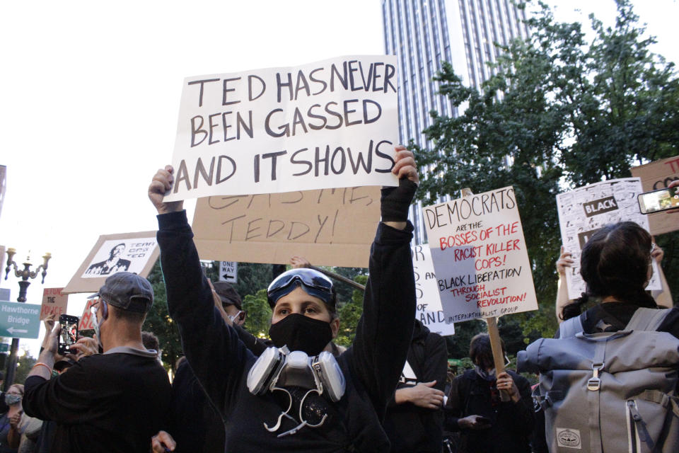 CORRECTS TITLE OF TED WHEELER TO MAYOR - Demonstrators protest in downtown Portland, Ore., Wednesday, July 22, 2020. Mayor of Portland Ted Wheeler faced a hostile crowd of protesters, who screamed at and sharply questioned him as he tried to rally demonstrators who have clashed repeatedly with federal agents sent in by President Donald Trump to quell ongoing unrest in the city. (AP Photo/Gillian Flaccus)