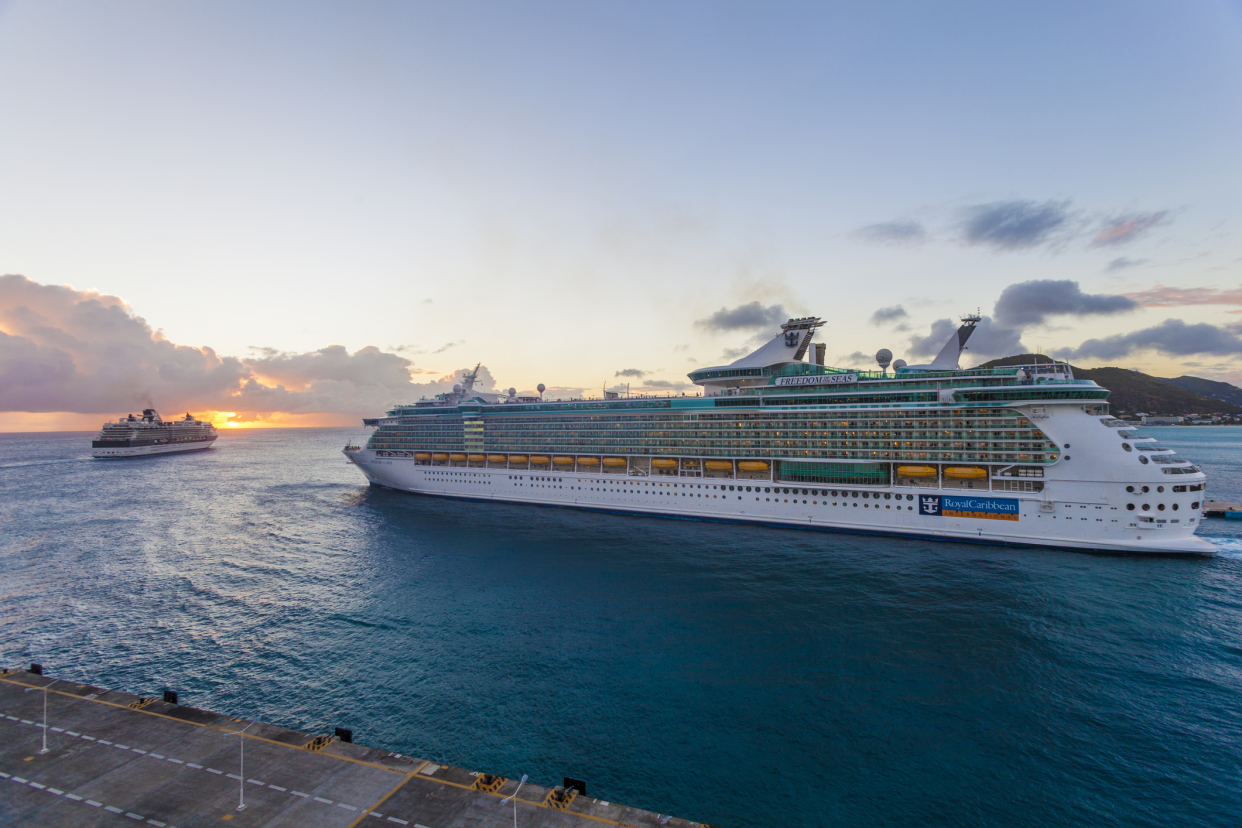 Royal Caribbean Cruise Ship Freedom of the Seas leaving port in Philipsburg, Sint Maarten during sunset, another ship in the background