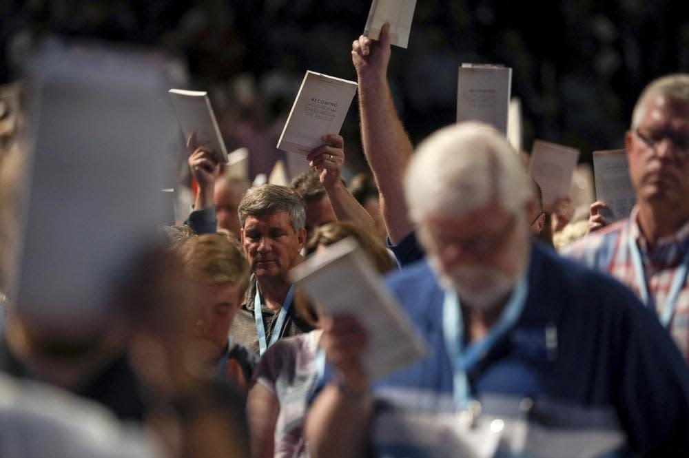 In this Wednesday, June 12, 2019 file photo, Bill Golden, and thousands of others, hold up copies of a training handbook related to sexual abuse within Southern Baptist churches during a speech by SBC President J. D. Greear on the second day of the SBC’s annual meeting in Birmingham, Ala. As Southern Baptists prepare for their biggest annual meeting in more than a quarter-century in June 2021, accusations that leaders have shielded churches from claims of sexual abuse and simmering tensions around race threaten to once again mire the nation’s largest Protestant denomination in a conflict that can look more political than theological. (Jon Shapley/Houston Chronicle via AP, File)