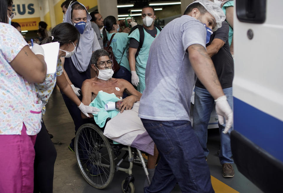 A patient is evacuated from the Bonsucesso Federal Hospital, which has a COVID-19 unit, while firefighters douse a fire in Rio de Janeiro, Brazil, Tuesday, Oct. 27, 2020. According to the fire department, there were no casualties. (AP Photo/Silvia Izquierdo)