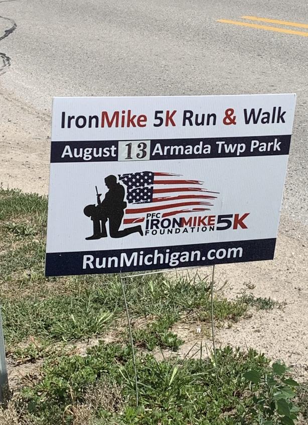 Sign for Iron Mike 5K Run & Walk at Armada Township Park on August 13. Organized by the PFC Iron Mike 5K Foundation. Information at RunMichigan.com