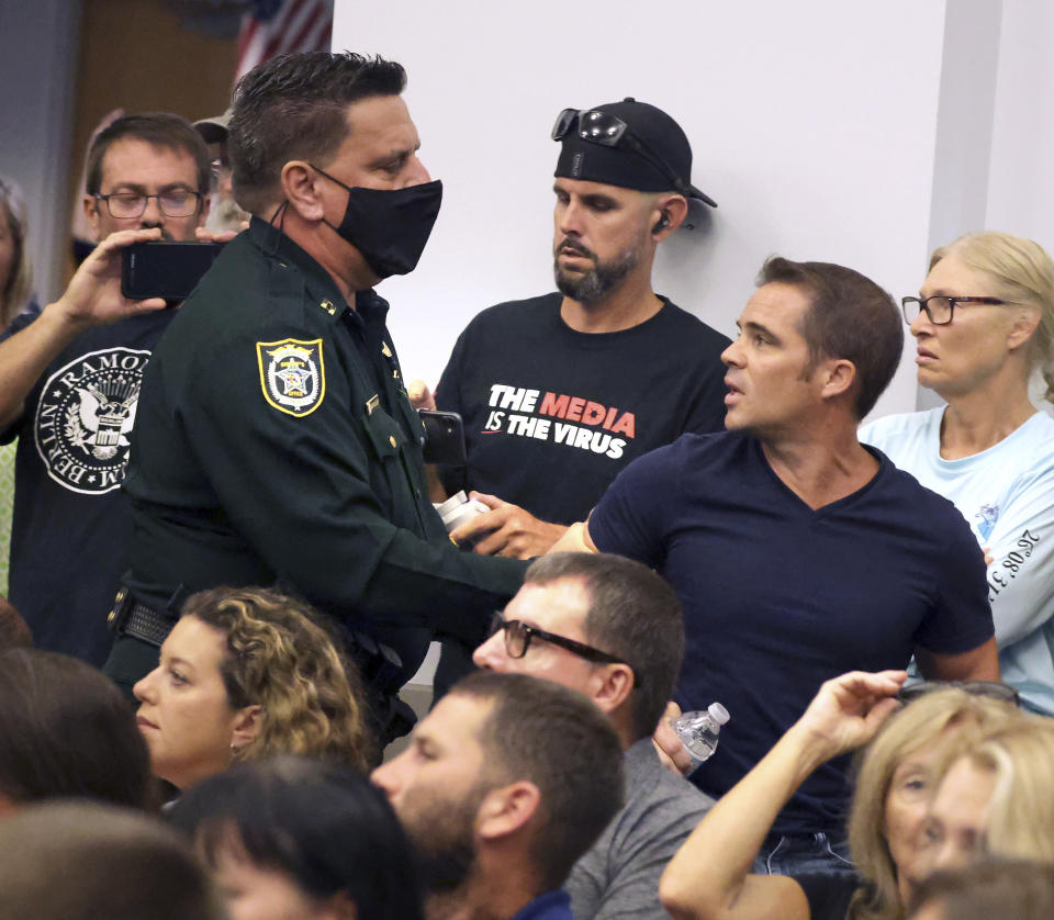 Seminole County, Fla., deputies remove parent Chris Mink of Apopka from an emergency meeting of the Seminole County School Board in Sanford, Fla., Thursday, Sept. 2, 2021. Mink, the parent of a Bear Lake Elementary School student, opposes a call for mask mandates for Seminole schools and was escorted out for shouting during the standing-room only meeting. (Joe Burbank /Orlando Sentinel via AP)