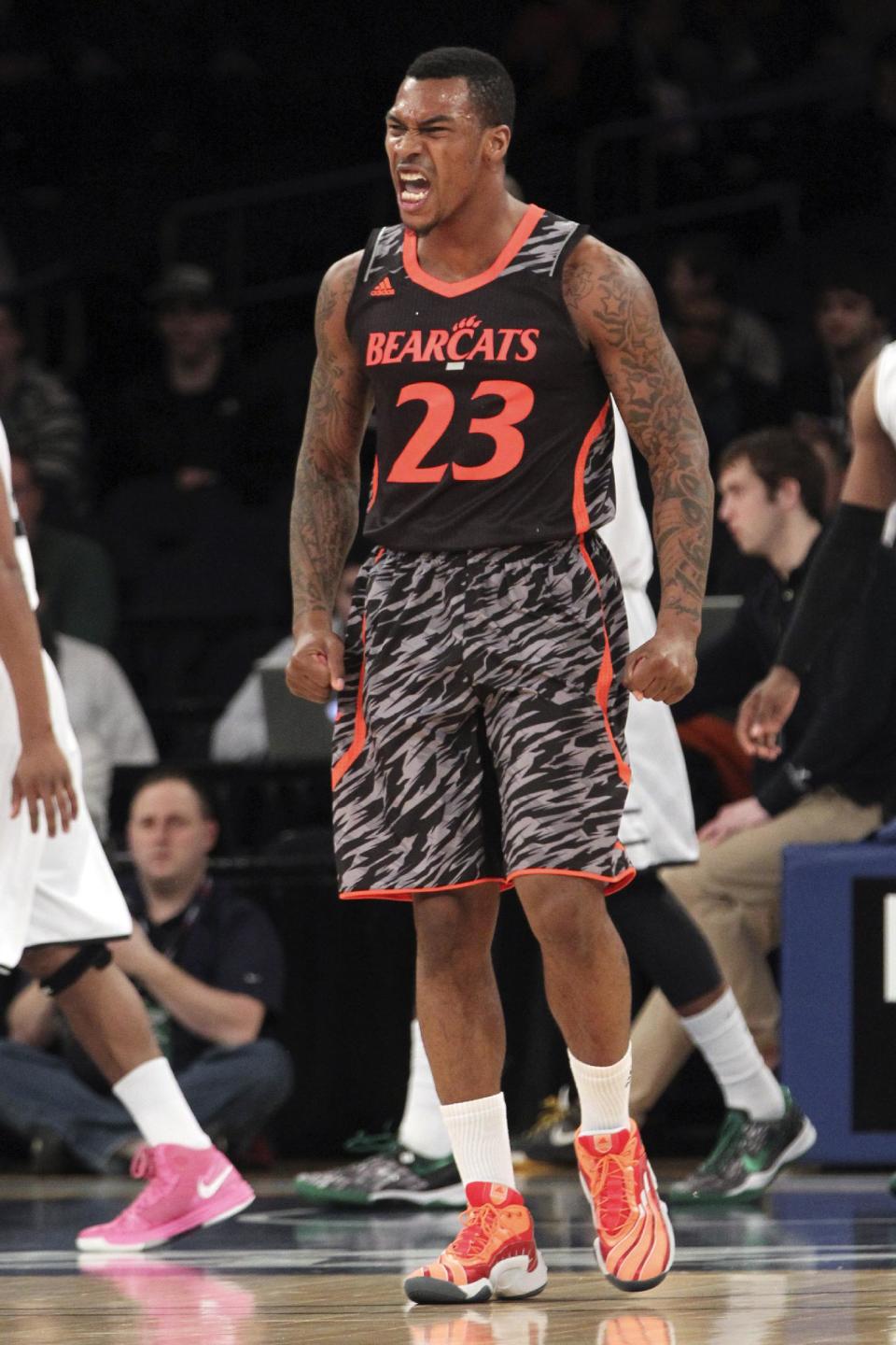 FILE - This March 13, 2013 file photo shows Cincinnati's Sean Kilpatrick reacting after making a basket during the first half of an NCAA college basketball game against Providence at the Big East Conference tournament in New York. The neon-colored jerseys and camouflage-covered shorts debuted by six teams in their post-season conference championships ahead of the NCAA men's basketball tournament weren't well received in the press and social media. The changes happened to be in line with fashion runways and in recreational athleticwear, where highlighter brights and creative camo have been bona fide trends, and alternate uniforms have become part of the college football and basketball landscape, but on the court, these uniforms still made fans cringe. (AP Photo/Mary Altaffer, file)