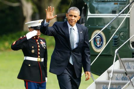 U.S. President Barack Obama waves as he arrives via Marine One helicopter at the White House in Washington October 14, 2014. REUTERS/Jonathan Ernst