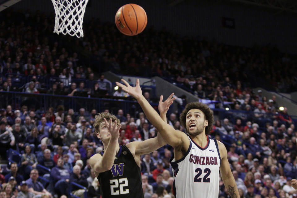 Washington guard Cole Bajema, left, and Gonzaga forward Anton Watson, right, go after the ball during the first half of an NCAA college basketball game, Friday, Dec. 9, 2022, in Spokane, Wash. (AP Photo/Young Kwak)