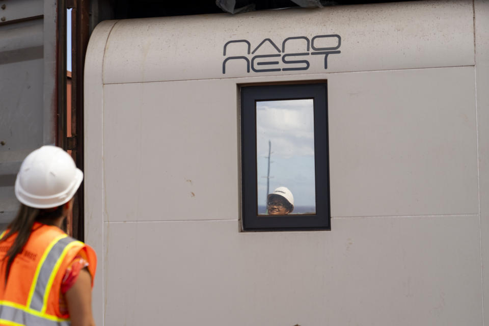 Kalewalani Bancaco, senior project manager for HomeAid Hawaii, stands in front of a Nano Nest, modular home unit planned for use in the housing development Ka La'i Ola, which aims to house up to 1,500 wildfire survivors in 450 modular units over the next five years, Thursday, July 11, 2024, in Lahaina, Hawaii. The development will be located on 57 acres of land near the Lahaina Civic Center, overlooking parts of the burn zone. (AP Photo/Lindsey Wasson)