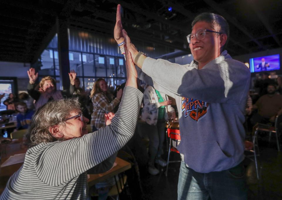 Ben Chan high-fives supporters during a watch party for Game 6 of the "Jeopardy!" Tournament of Champions finals on Tuesday at Zambaldi Beer in Allouez. Chan, who lives in Green Bay, finished the tournament in second place behind Yogesh Raut.