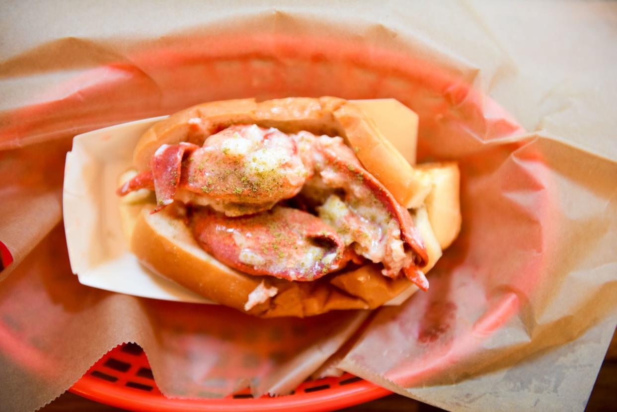 Top-View of a Lobster Roll on Brown Wrapping Paper in a Red Basket