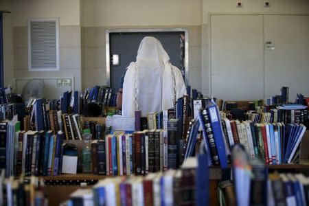 A student is covered in a Jewish prayer shawl as he prays at the Bnei David academy, the first religious military prep school and Jewish seminary, in the West Bank Jewish settlement of Eli, south of Nablus, January 31, 2016. REUTERS/Ronen Zvulun