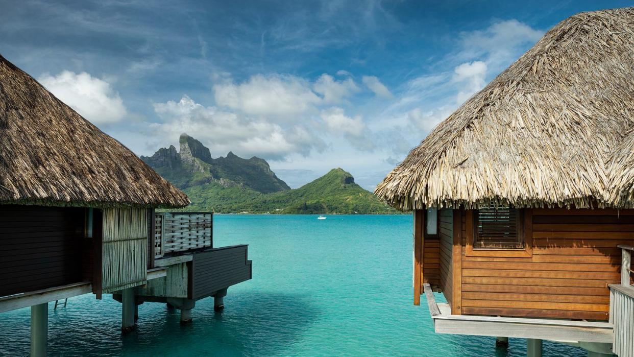 a couple of buildings on a dock over a body of water