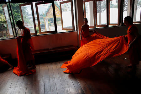 Boys prepare their novice robes at Wat Klang Thung temple where they temporarily live after entering the Buddhist novicehood in Mae Hong Son, Thailand, April 14, 2018. REUTERS/Jorge Silva