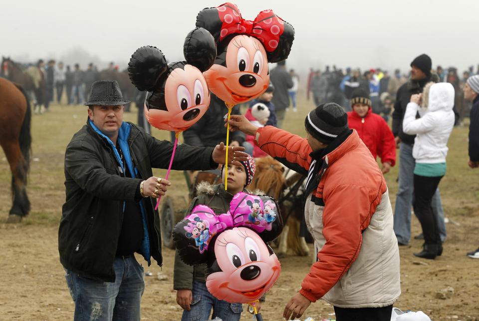 People buy balloons after the annual race organized by Orthodox believers on Epiphany Day in the Romanian village of Pietrosani