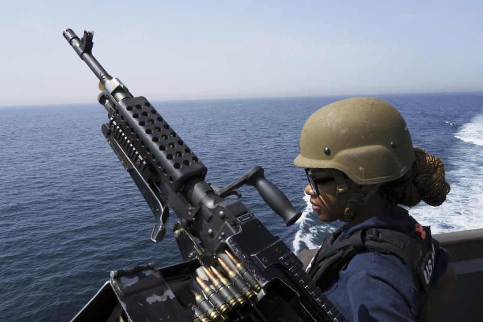 FILE - U.S. Navy retail service specialist Artayja Stewart of Clarksville, Tenn., stands guard next to a machine gun aboard the USS Paul Hamilton in the Strait of Hormuz Friday, May 19, 2023. Thousands of Marines backed by the United States' top fighter jet, warships and other aircraft are slowly building up in the Persian Gulf. It's a sign that while America's wars in the region may be over, its conflict with Iran over its advancing nuclear program only continues to worsen with no solutions in sight. (AP Photo/Jon Gambrell, File)