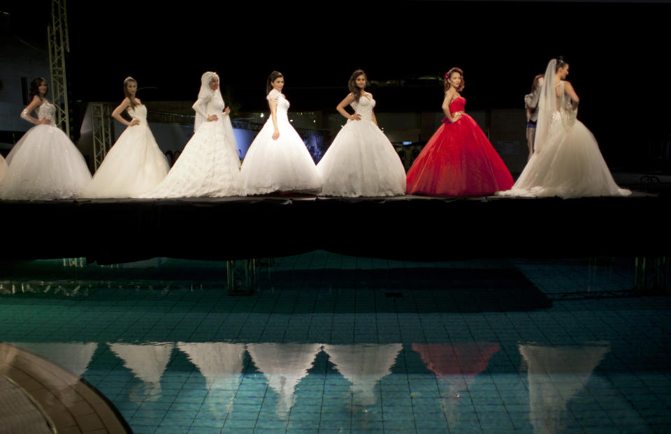 In this photo taken Friday, May 2, 2014, models display creations by designer Fayzeh Pearl on the catwalk during a fashion show on the second day of Palestine Fashion Week 2014, in the West Bank city of Ramallah. (AP Photo/Nasser Nasser)